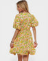 Woman wearing a colorful floral dress on a white background