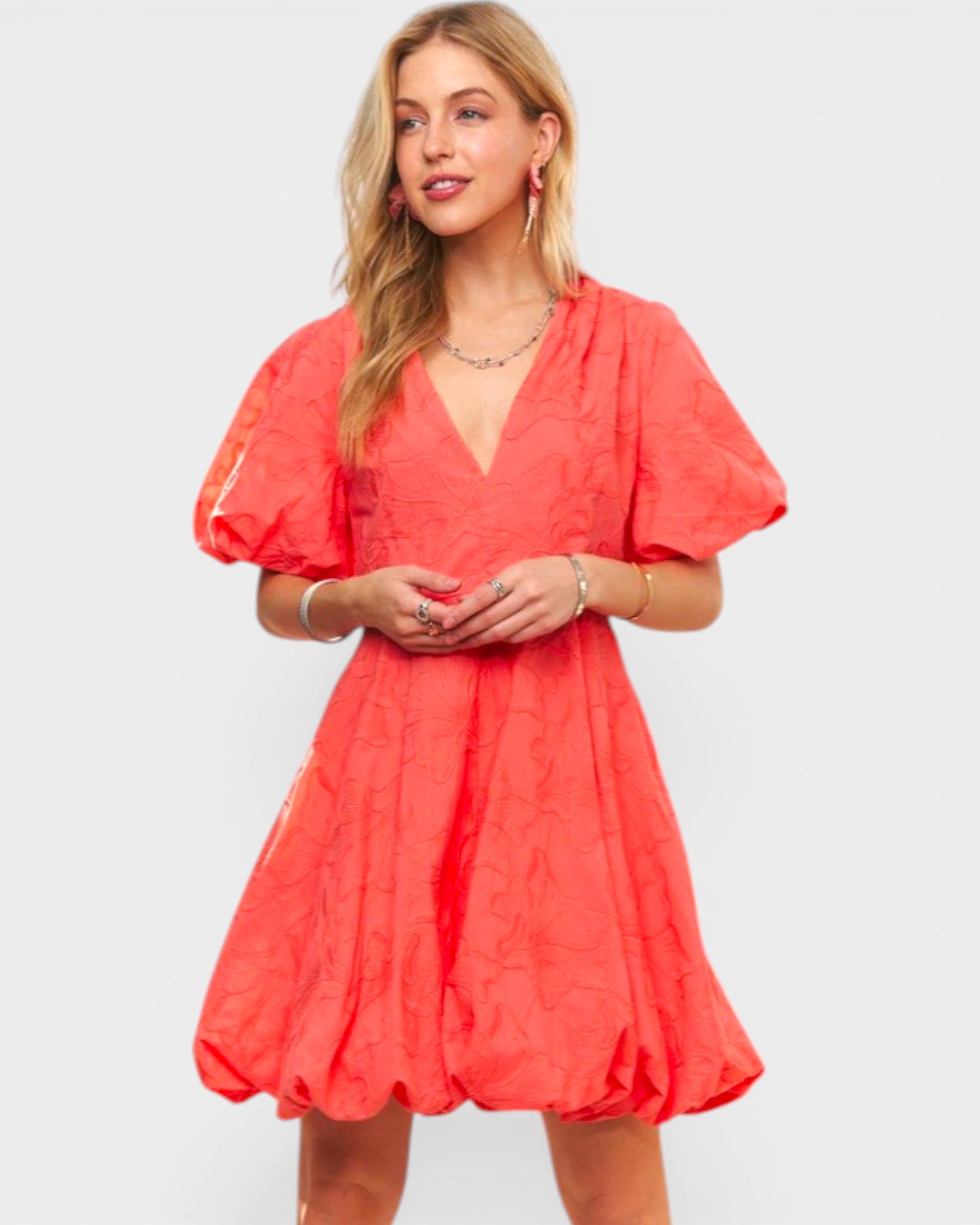 Woman wearing a coral dress on a white background
