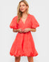 Woman wearing a coral dress on a white background