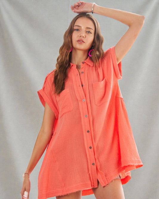 Woman wearing a coral-colored shirt against a plain background