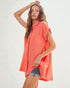Woman wearing a coral sleeveless shirt against a white background