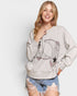 Woman wearing a gray sweatshirt with a dolphin design on a white background