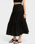 Black tiered skirt with white polka dots worn by a person on a white background