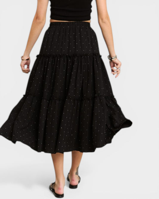 Black polka dot skirt worn by a person on a white background