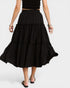 Black polka dot skirt worn by a person on a white background