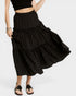 Black tiered skirt with white polka dots worn by a person on a white background