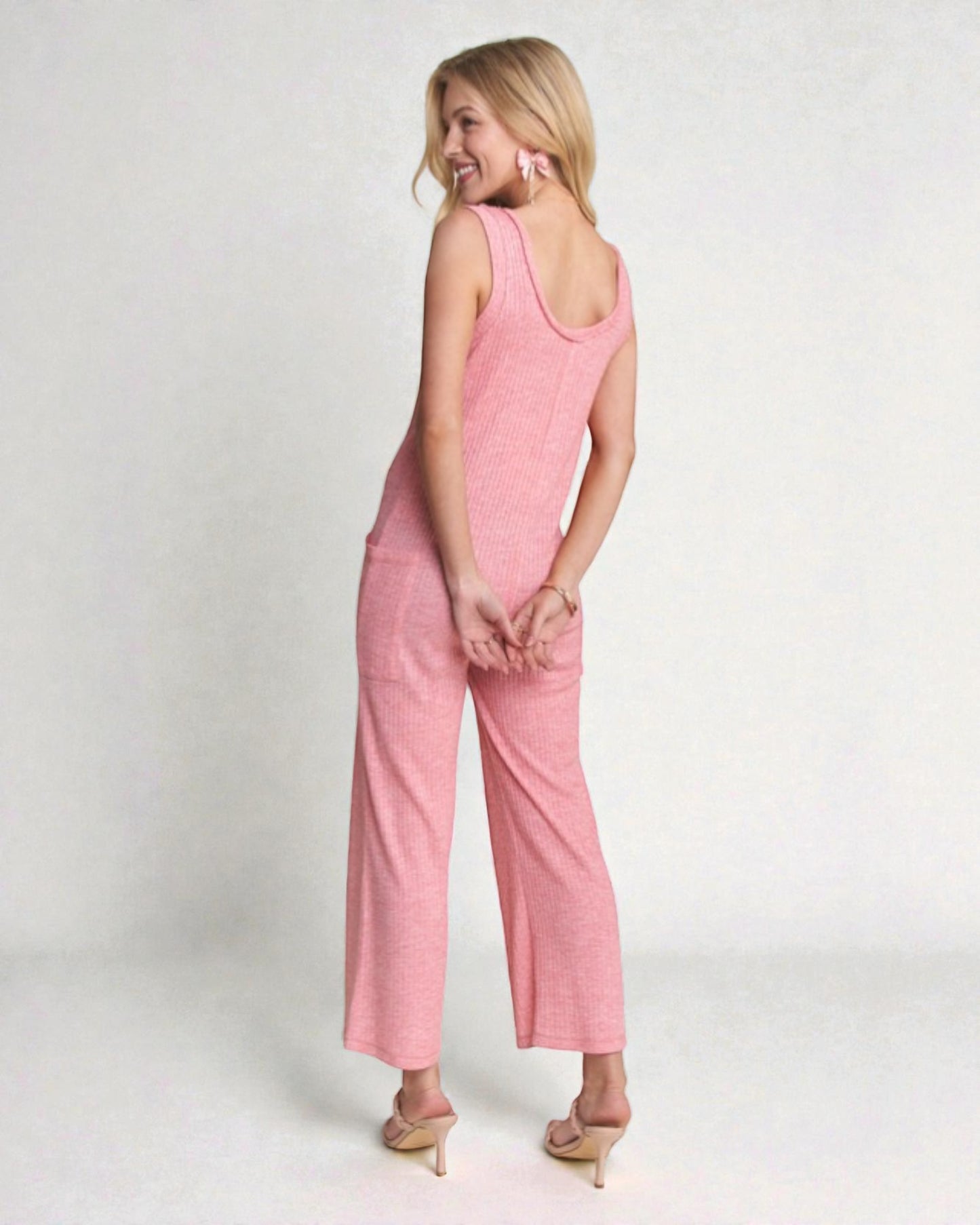Woman wearing a pink jumpsuit on a white background