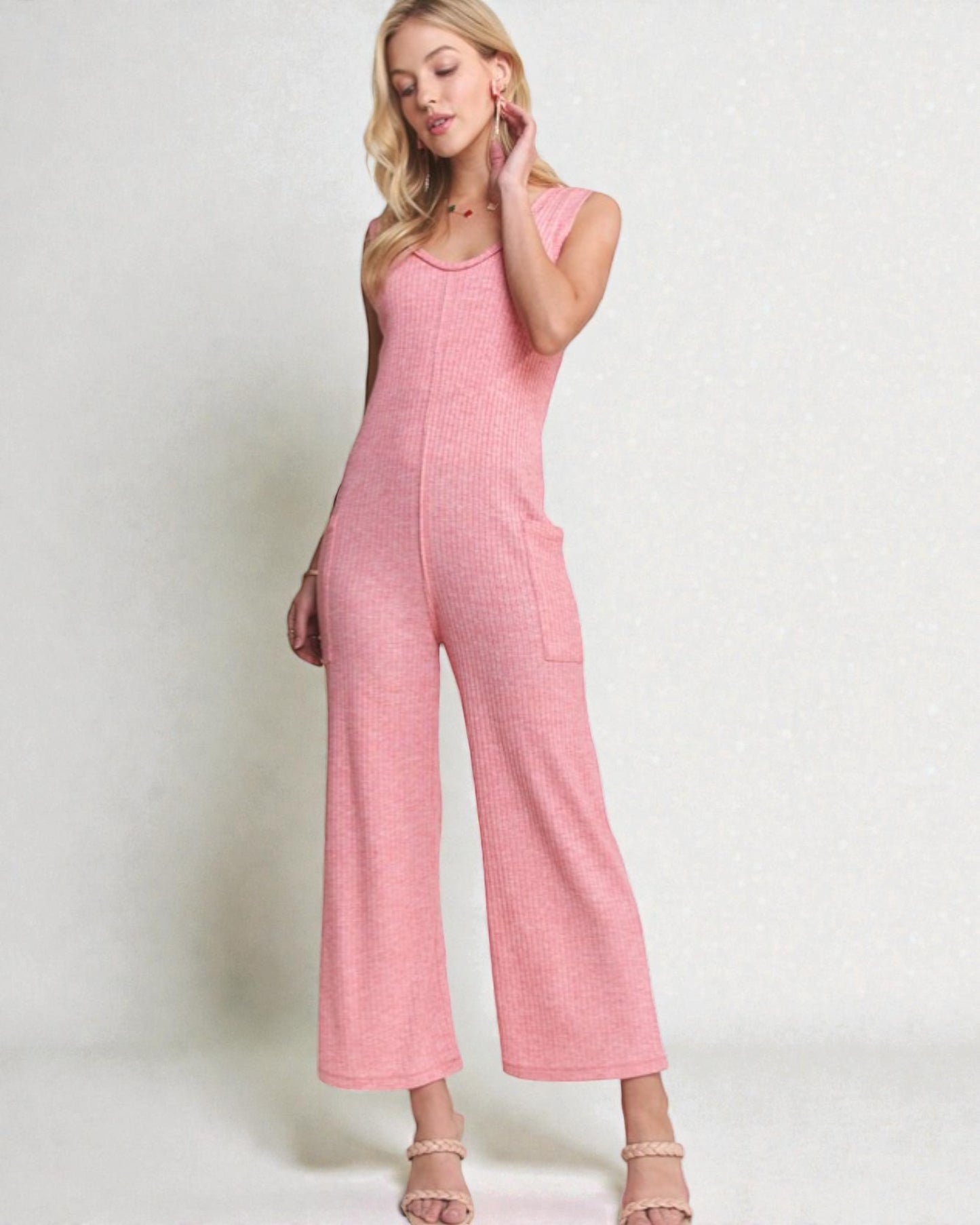 Woman wearing a pink jumpsuit against a white background