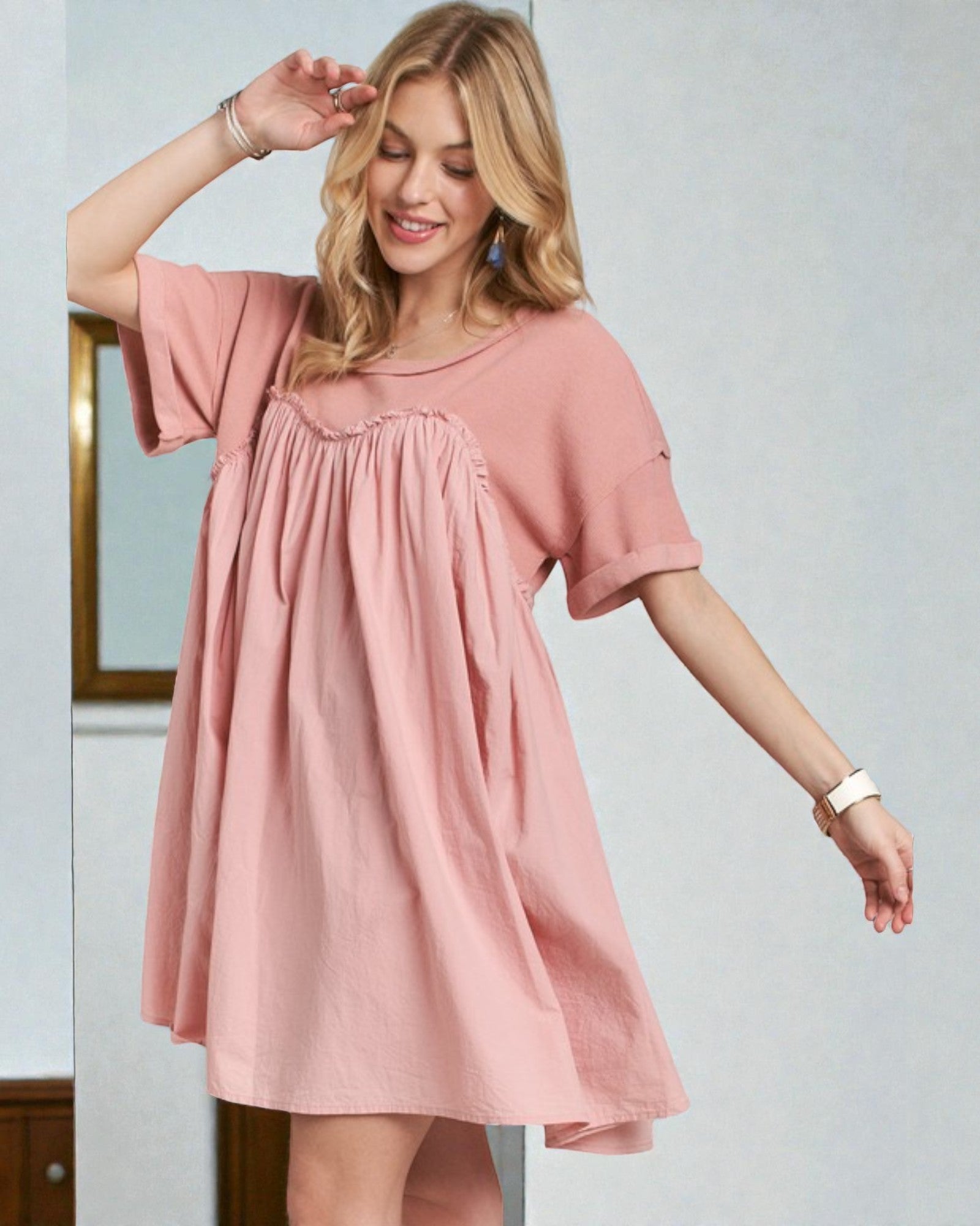 Woman wearing a pink dress against a plain background