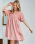 Woman wearing a pink dress against a plain background