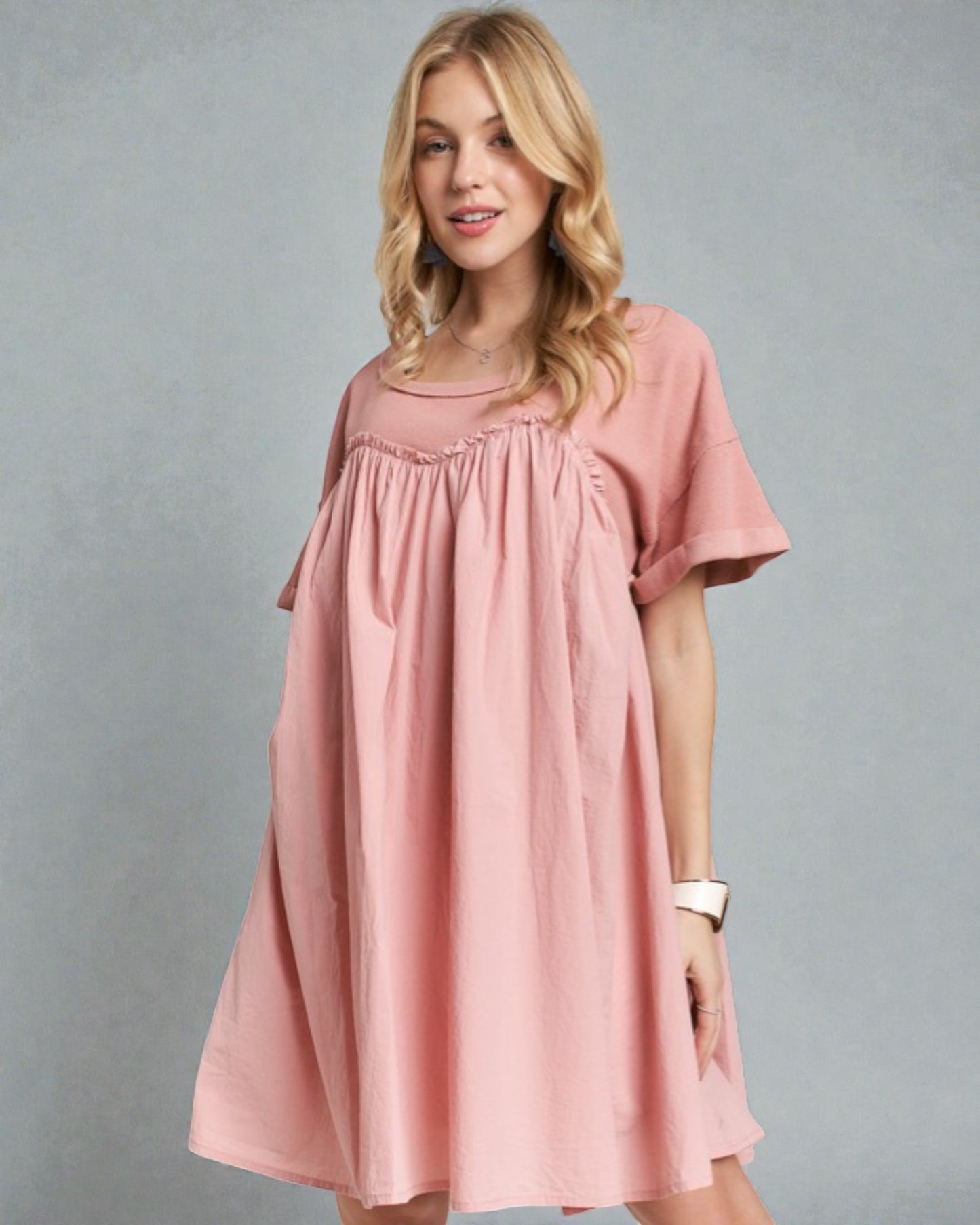 Woman wearing a pink dress against a gray background