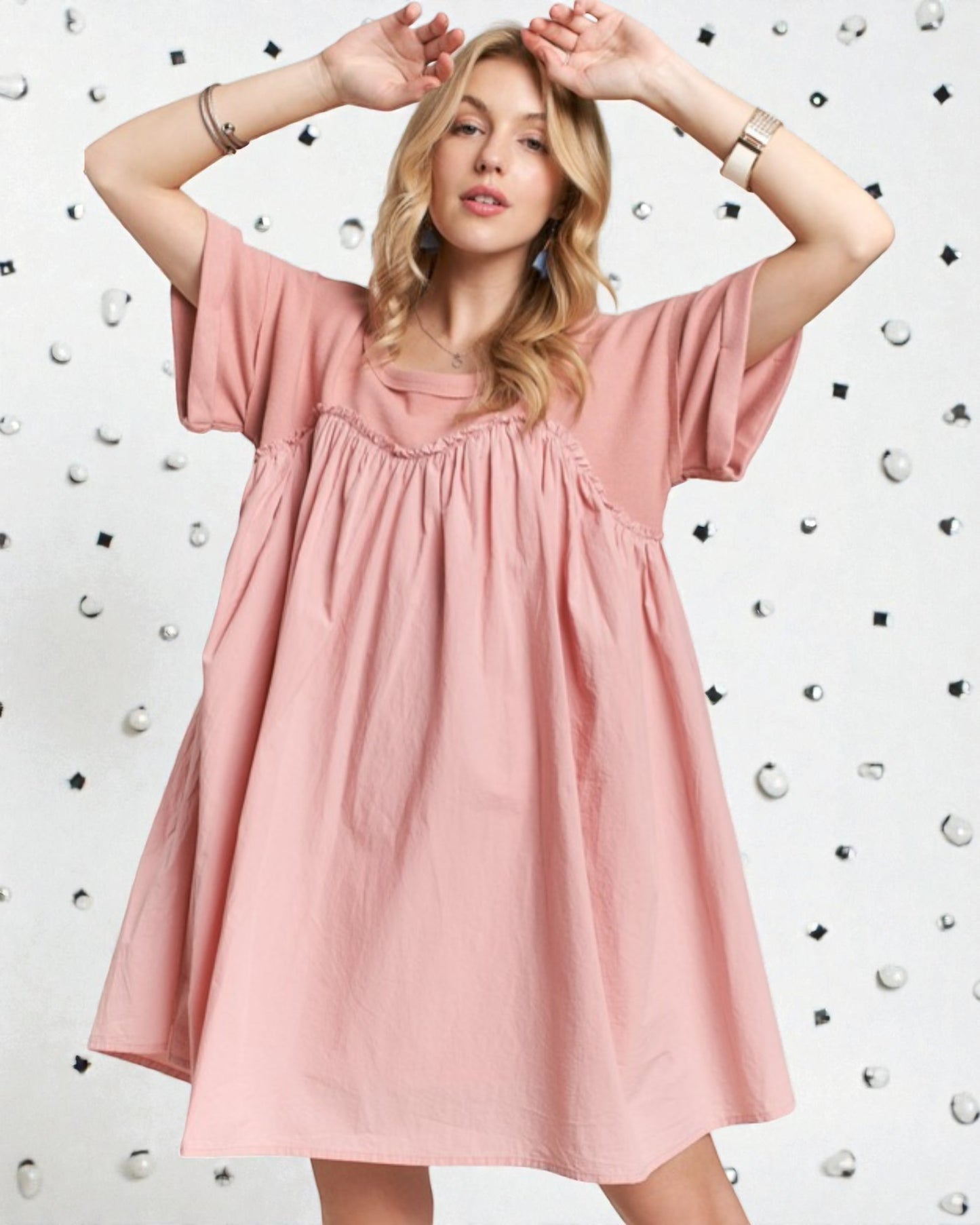 Woman wearing a pink dress against a white background with black shapes