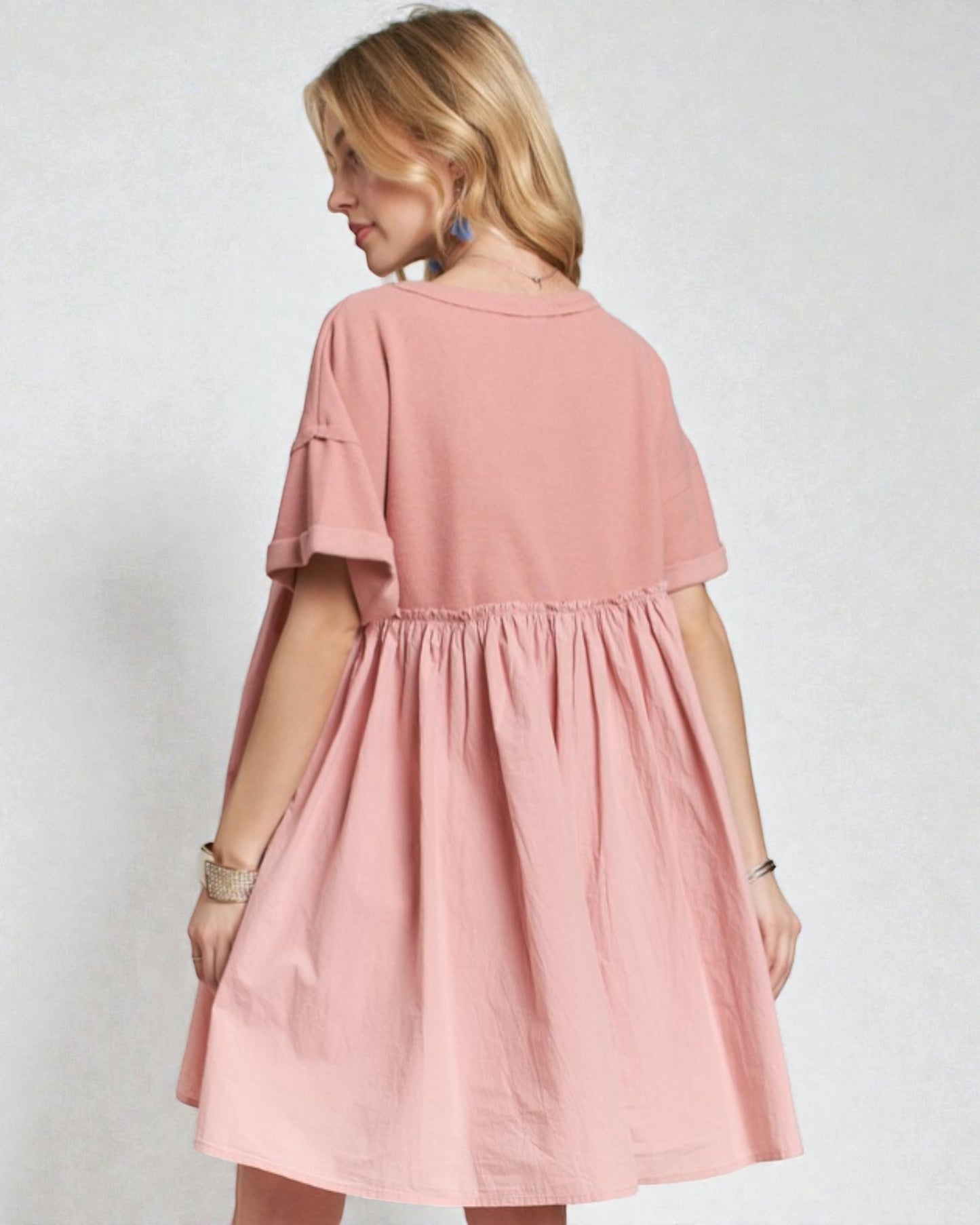 Woman wearing a pink dress against a plain background