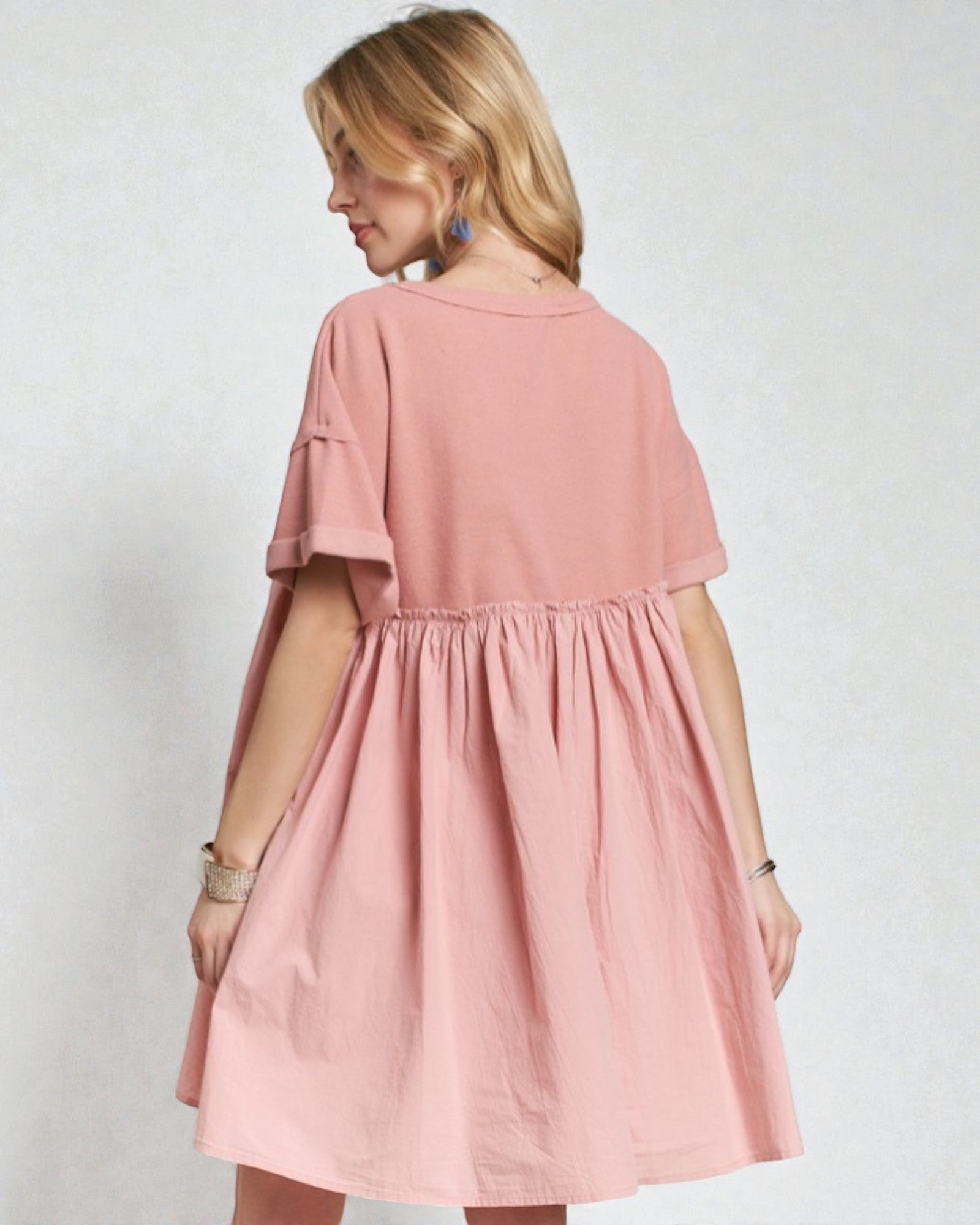 Woman wearing a pink dress against a plain background