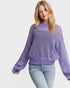 Woman wearing a purple sweater with a white background