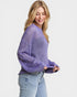 Woman wearing a purple open-knit sweater on a light gray background