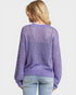 Person wearing a purple mesh sweater on a white background