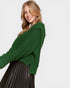 Woman wearing a green sweater on a plain background