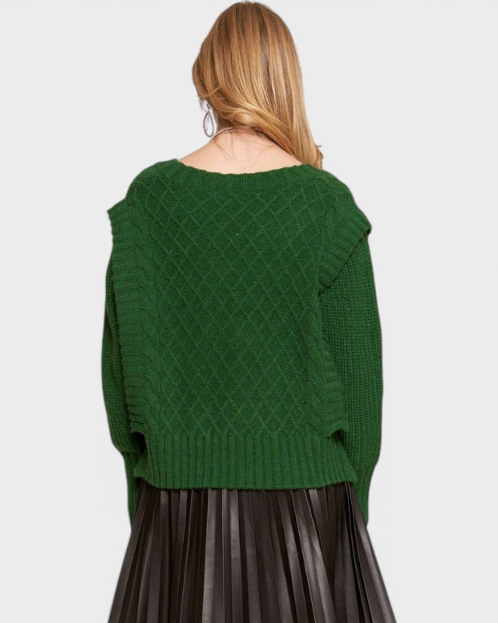 Green knitted sweater worn by a person on a light gray background