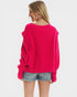 Person wearing a bright pink sweater and denim shorts on a white background