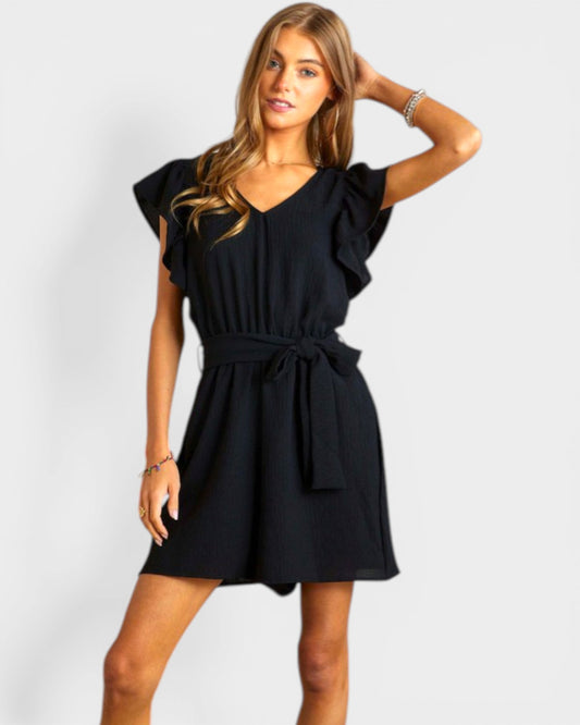 Woman wearing a black romper on a white background