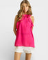 Woman wearing a bright pink sleeveless top with ruffles on a white background