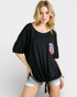 Woman wearing a black oversized t-shirt with an American flag pocket on a white background