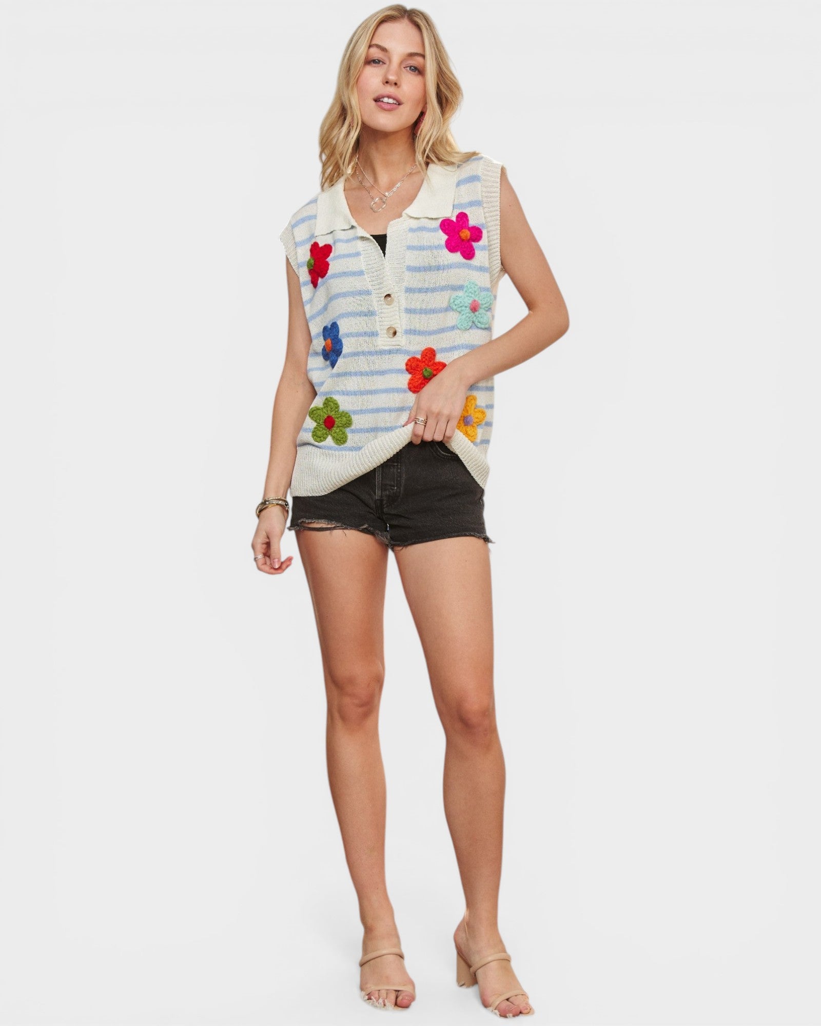 Woman wearing a colorful striped vest with floral patterns on a white background