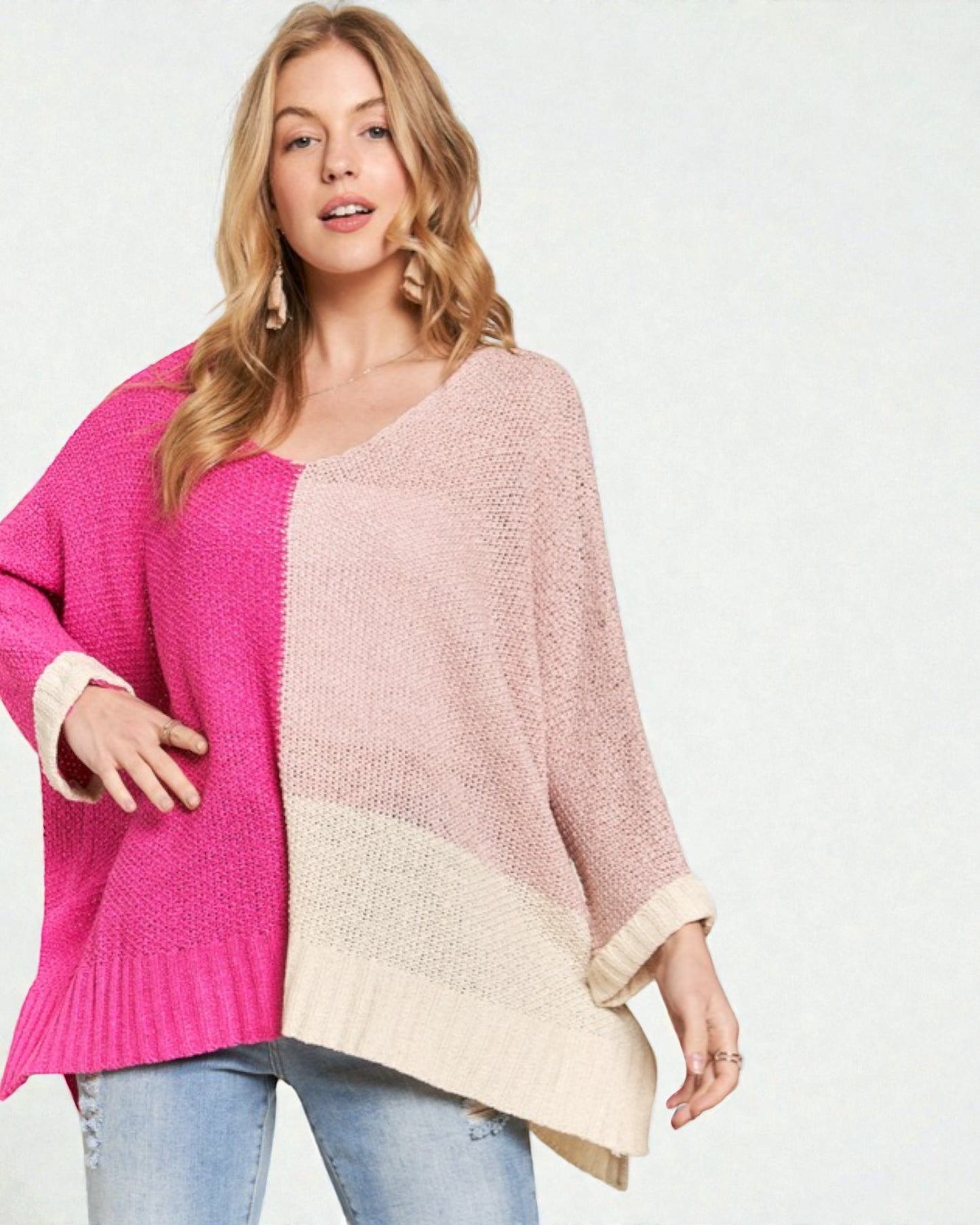 Woman wearing a two-tone pink and beige sweater on a white background