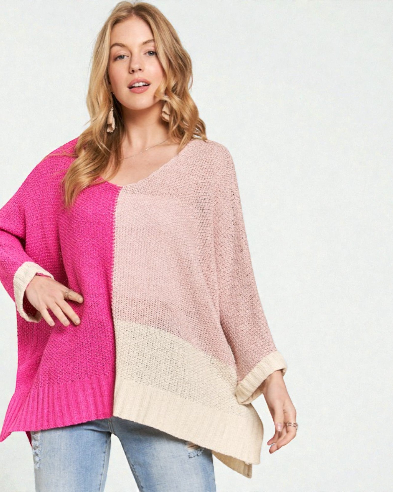 Woman wearing a two-tone pink and beige sweater on a white background