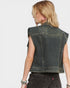 Denim vest with embellishments on a plain background