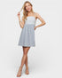 Woman wearing a light blue dress with a white lace top on a white background