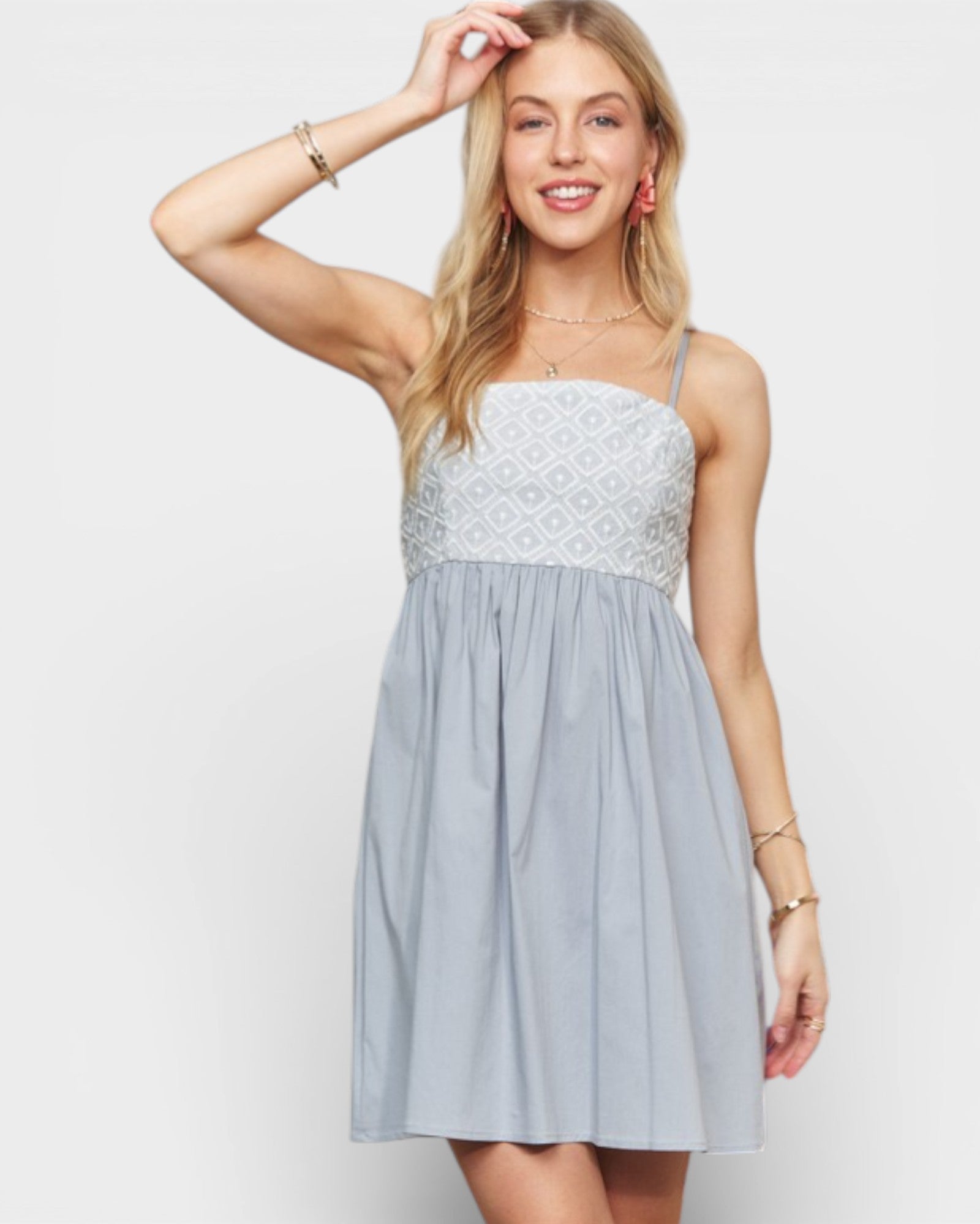 Woman wearing a light blue dress with lace details on a white background