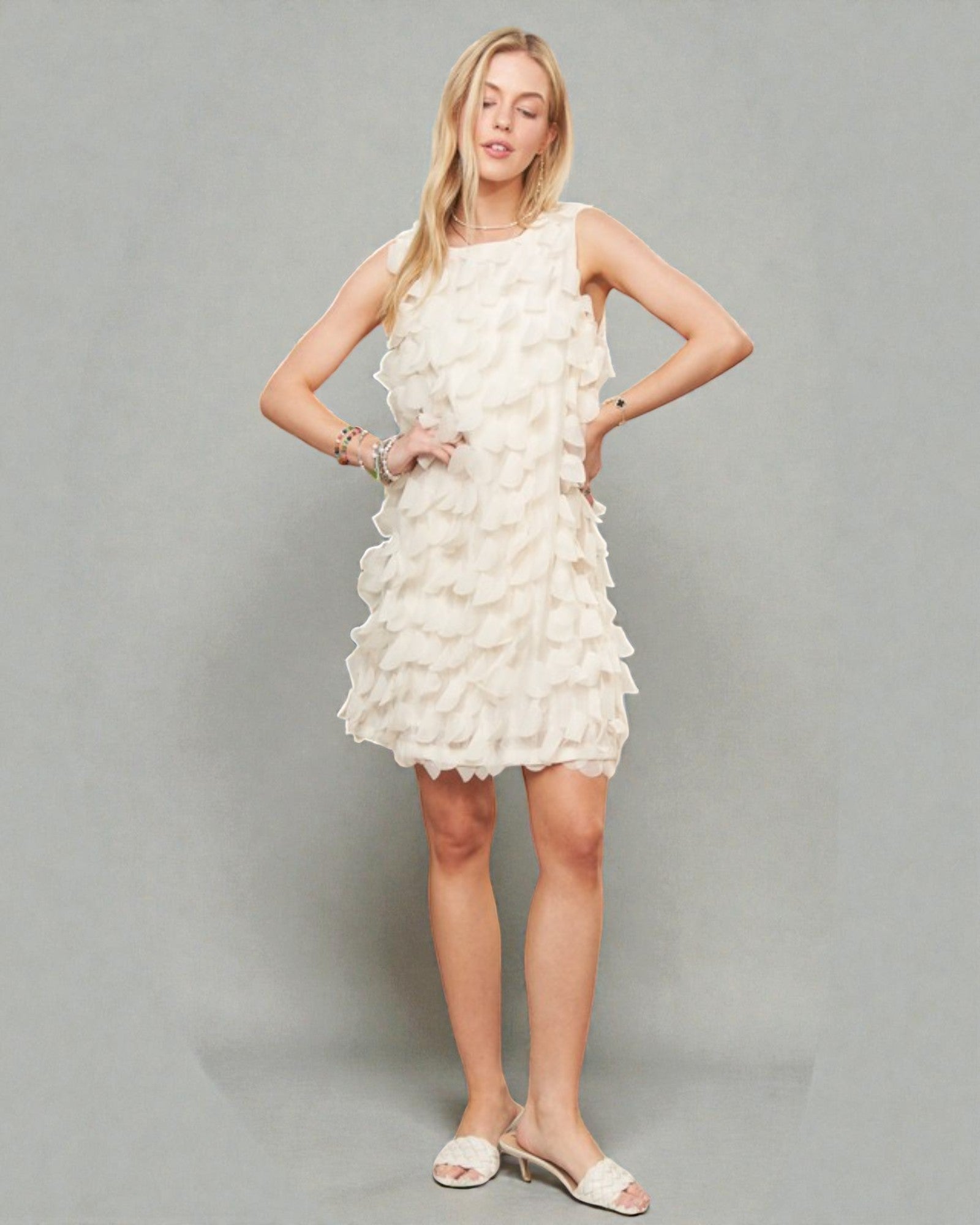 Woman wearing a white ruffled dress against a gray background