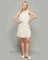 Woman wearing a white ruffled dress against a gray background