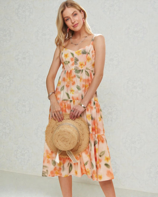 Woman wearing a floral dress holding a straw hat against a light background