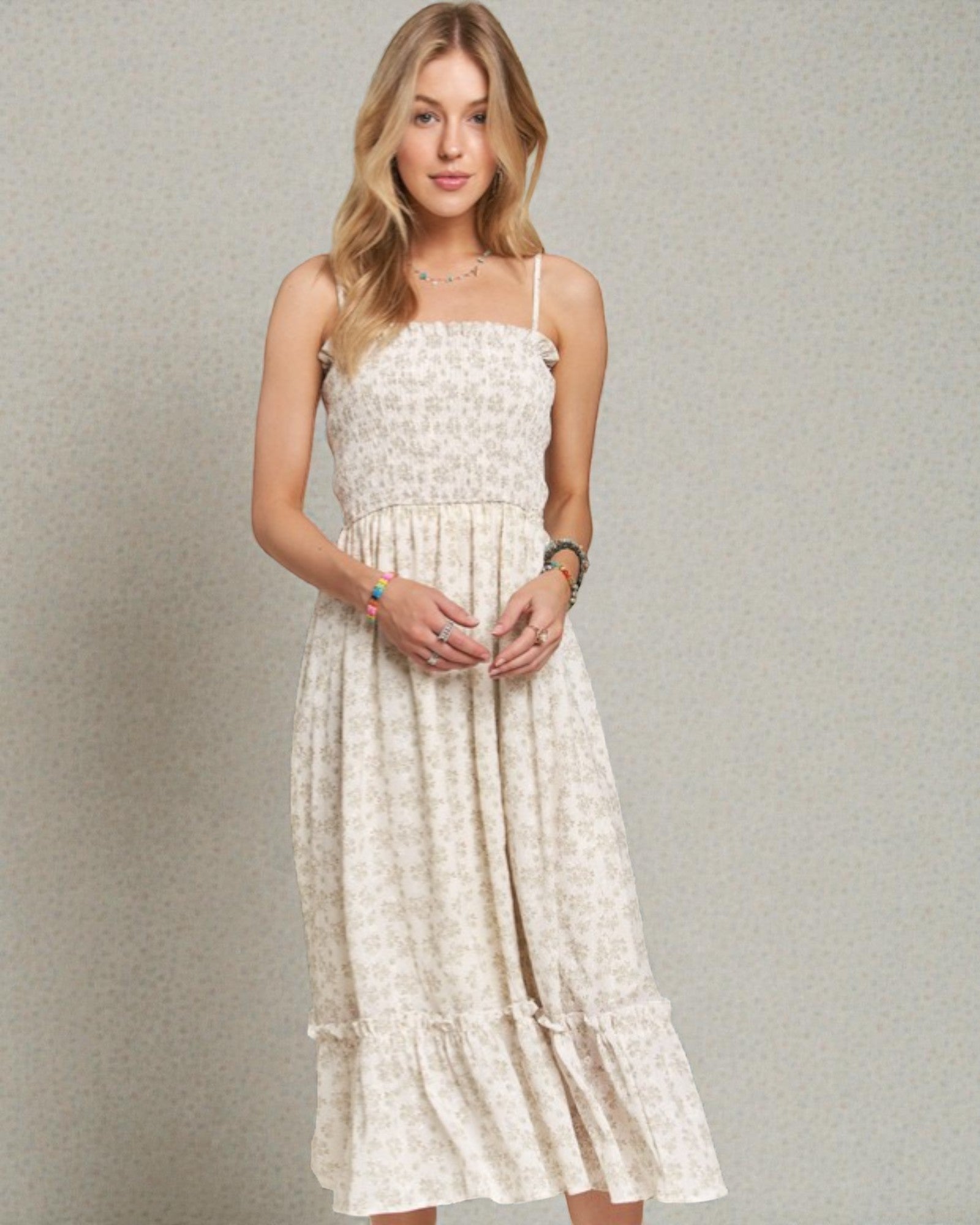 Woman wearing a white floral dress against a plain background