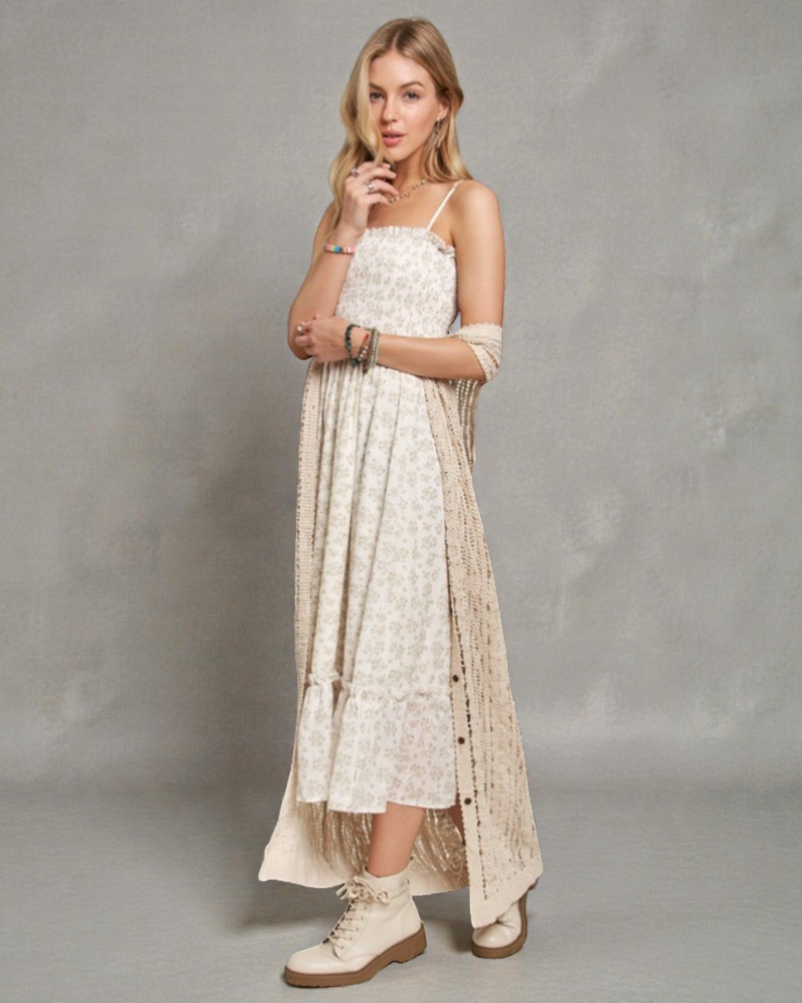 Woman wearing a long, light-colored dress with a plain background