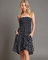 Woman wearing a strapless navy floral dress against a gray background