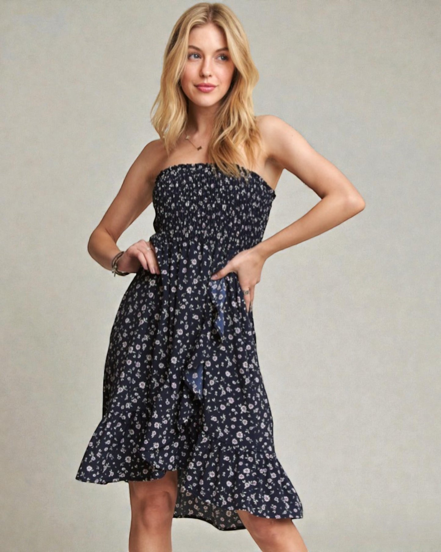 Woman wearing a strapless floral dress against a plain background