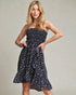 Woman wearing a strapless floral dress against a plain background