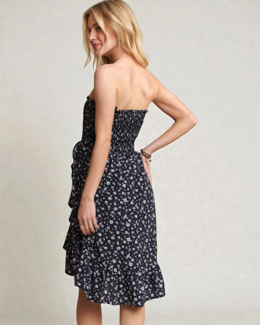 Woman wearing a strapless floral dress against a plain background