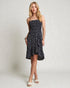 Woman wearing a black floral strapless dress on a plain background
