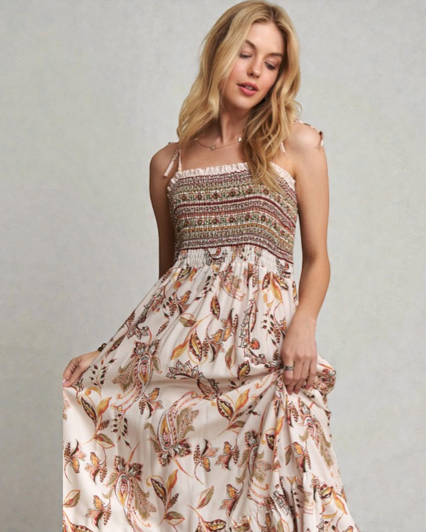 Woman wearing a floral dress against a plain background