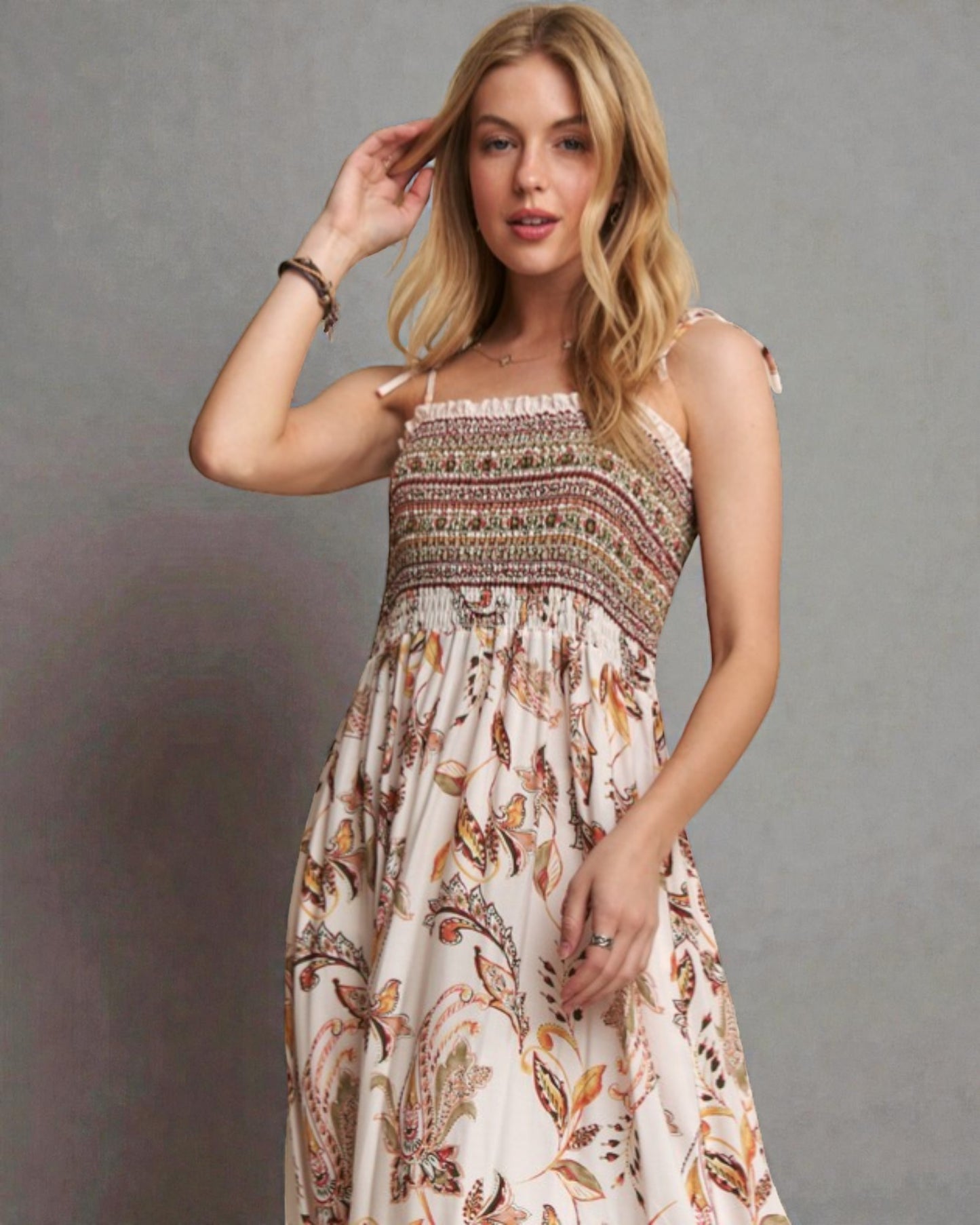 Woman wearing a patterned dress against a gray background