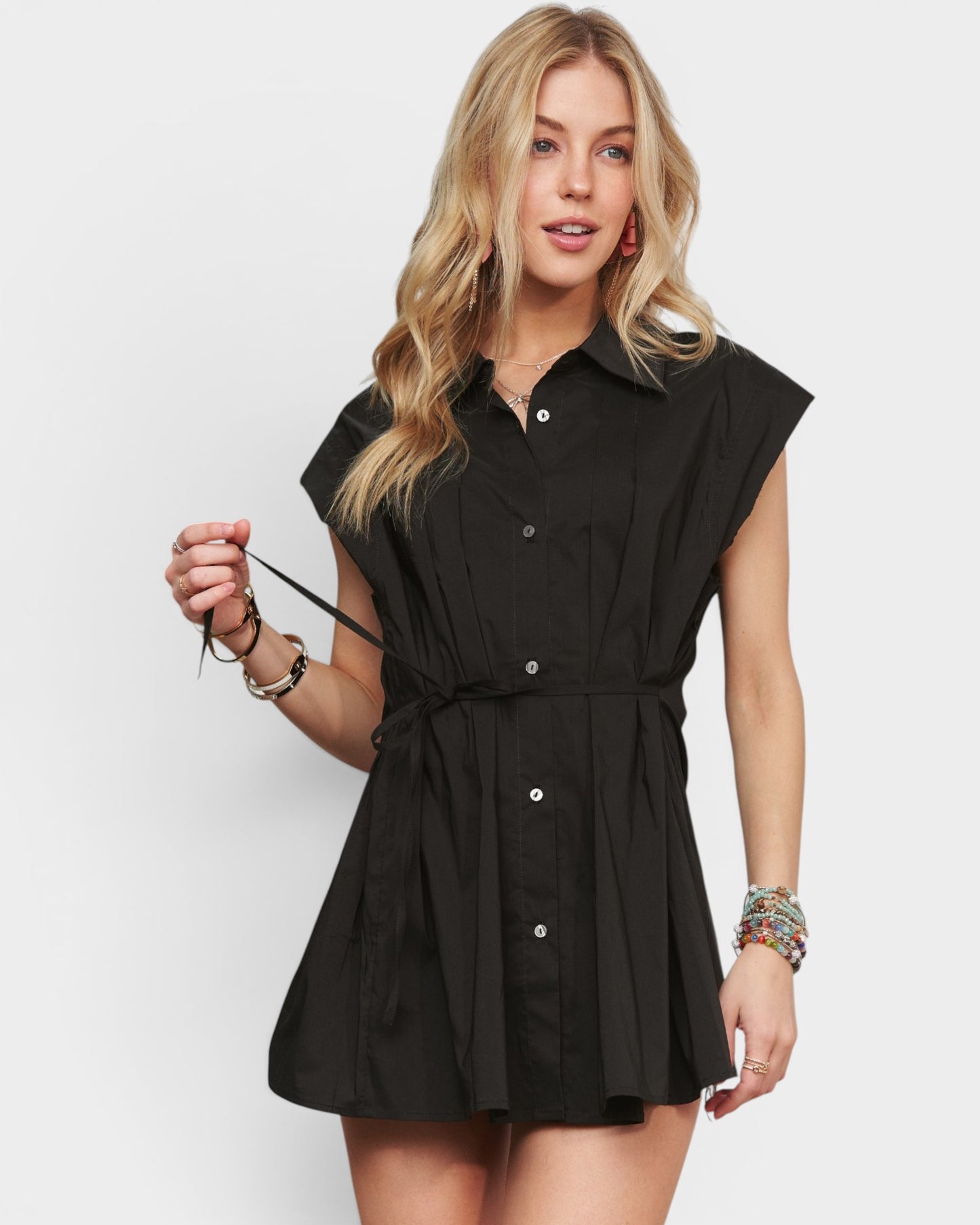 Woman wearing a black sleeveless dress against a white background