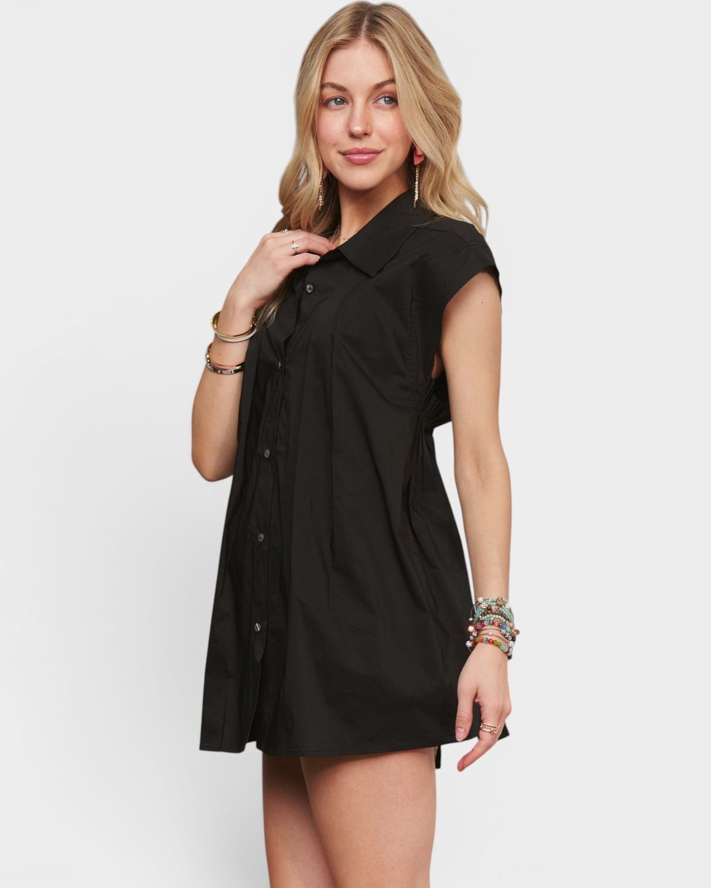 Woman wearing a black shirt dress on a white background