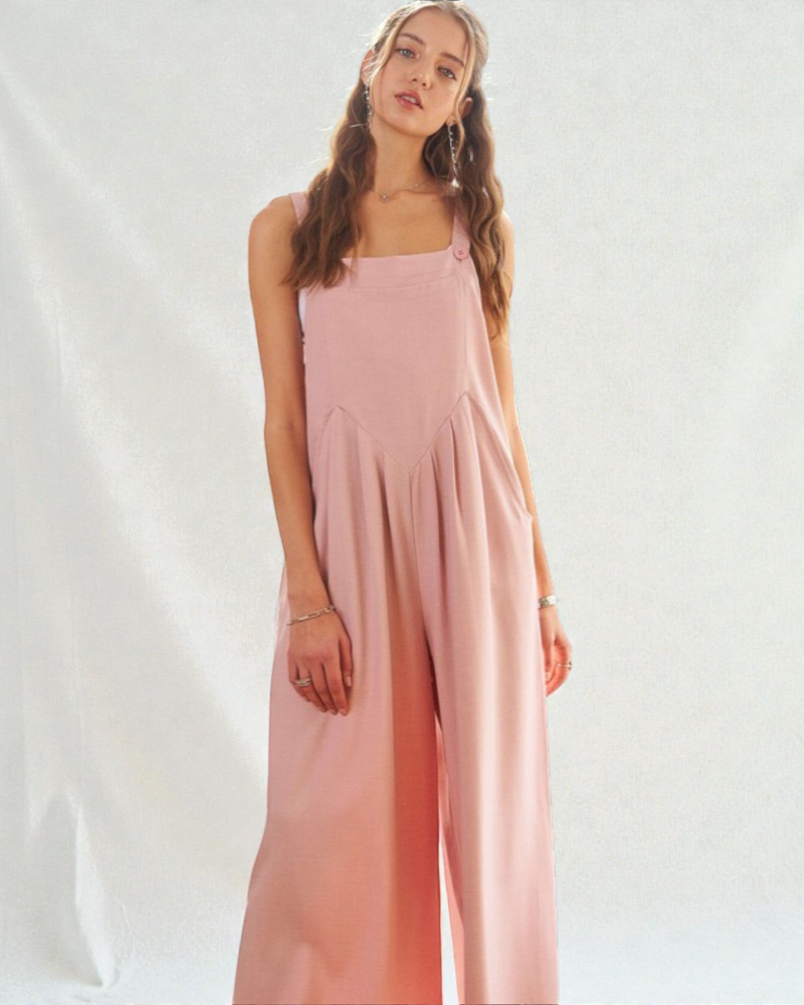 Woman wearing a pink jumpsuit on a white background