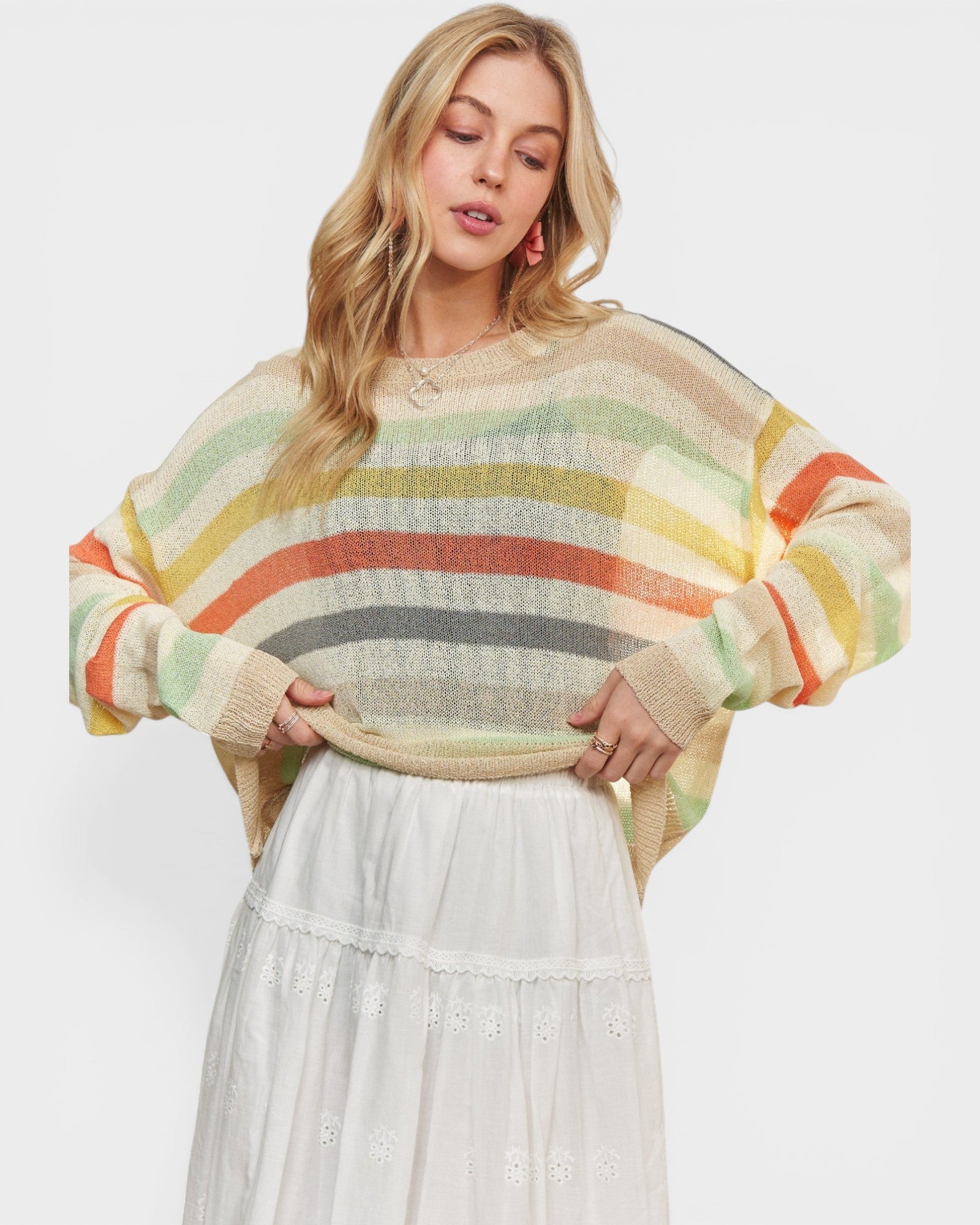Woman wearing a colorful striped sweater with a plain background