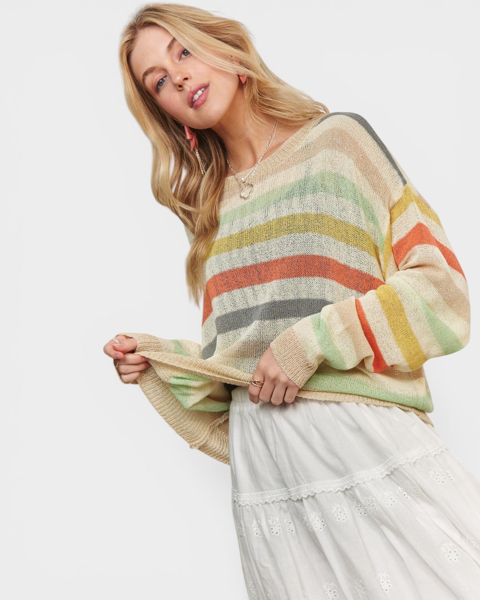 Woman wearing a colorful striped sweater against a white background